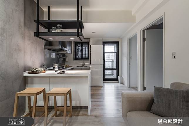 現代簡約風格的廚房，帶有木質吧椅，白色櫥櫃搭配黑色牆面，整體設計兼具實用性和美觀。