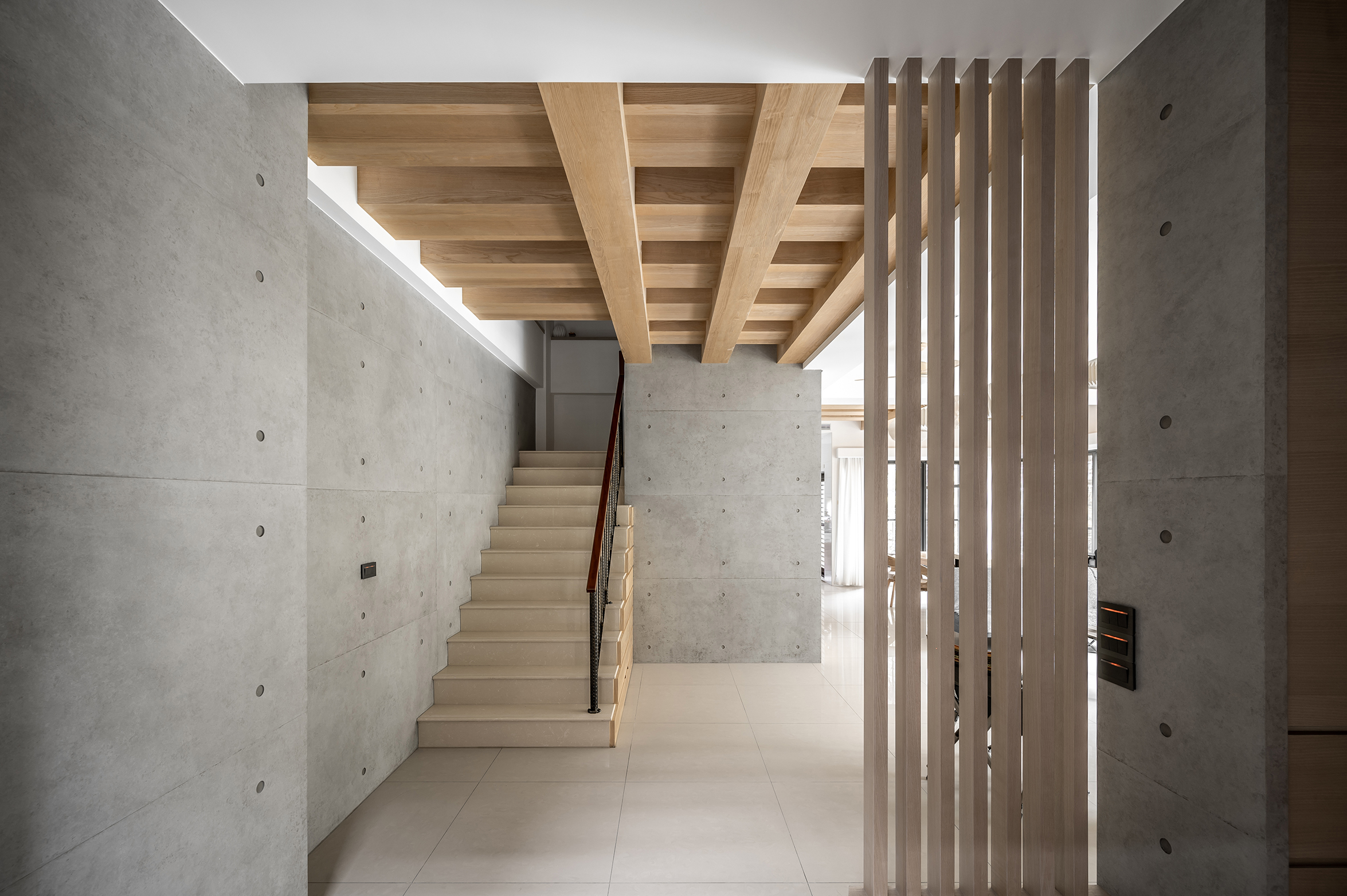 Staircase transition with wood ceiling and slatted partition by Tectona Design